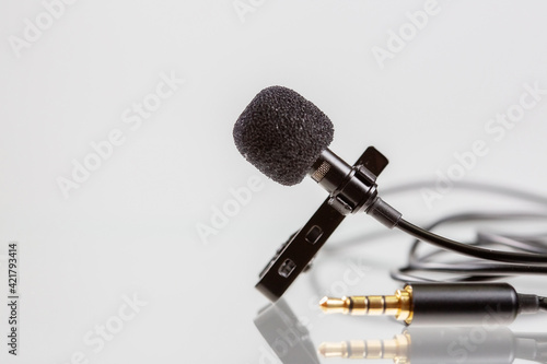 Small lavalier microphone or lapel mic with clip on white background. photo