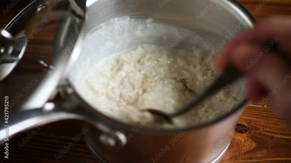sweet boiled oatmeal in a saucepan with a spoon sweet boiled oatmeal in a saucepan with a spoon
