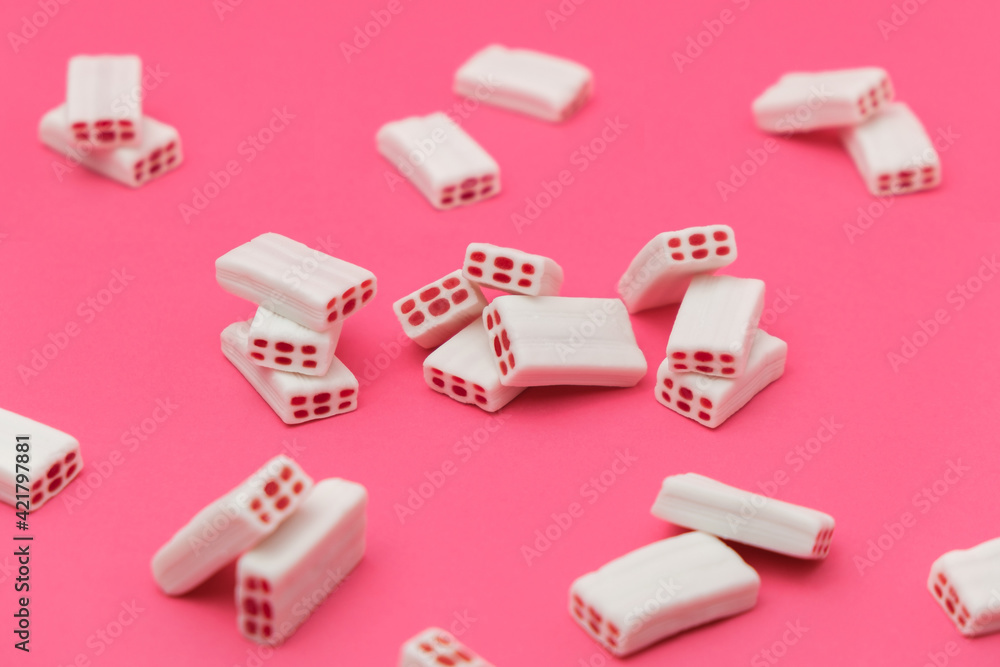 White tasty candies on a pink background. White tasty candies on a pink background.