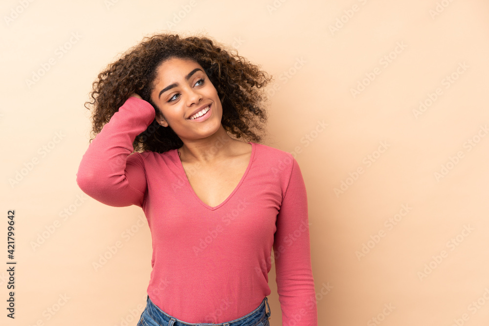 Young African American woman isolated on beige background thinking an idea Young African American woman isolated on beige background thinking an idea