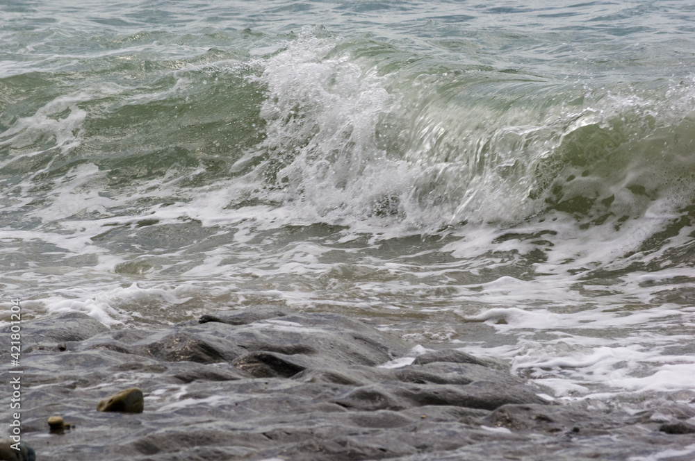 pebble stones on the sea beach, the rolling waves of the sea with foam pebble stones on the sea beach, the rolling waves of the sea with foam