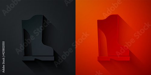 Paper cut Waterproof rubber boot icon isolated on black and red background. Gumboots for rainy weather, fishing, gardening. Paper art style. Vector