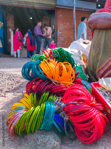 Stock photo of bunch of colorful bangles made of glass kept on roadside for sale in sunny afternoon at Indian market ,focus on glass bangles. photo