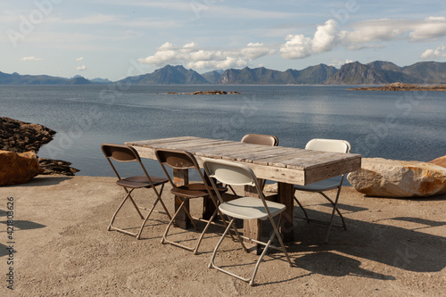 Table with chairs against the backdrop of the bay and mountains © Alernon77