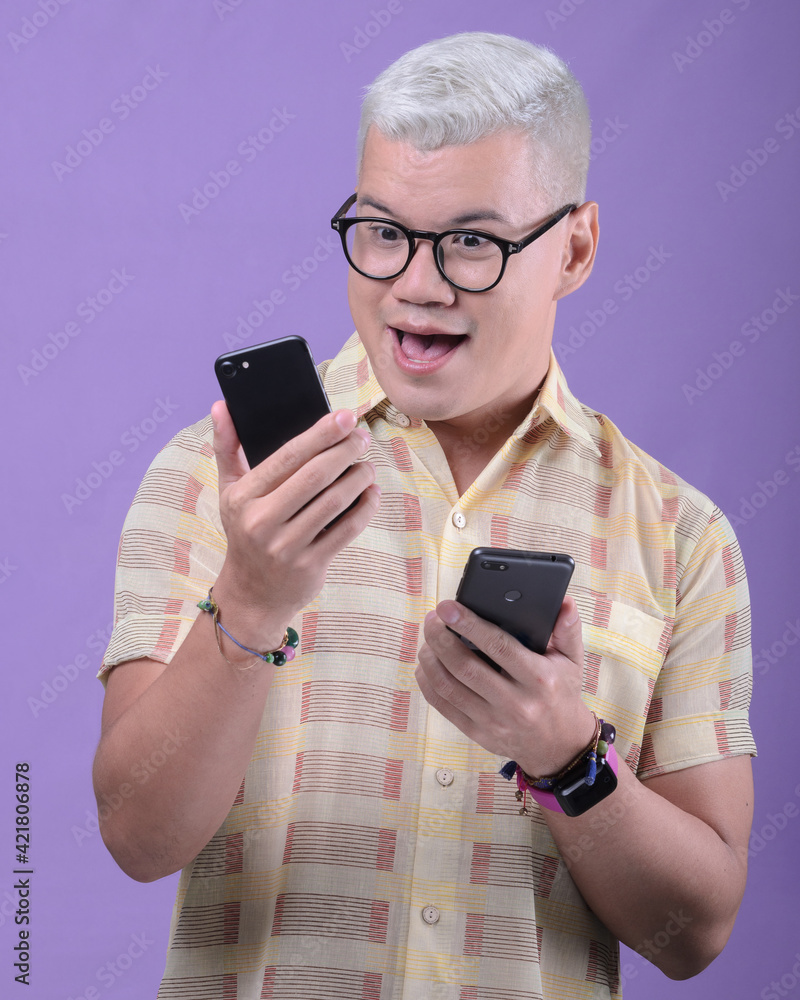 Surprised man with two cell phones in hand. Surprised man with two cell phones in hand.