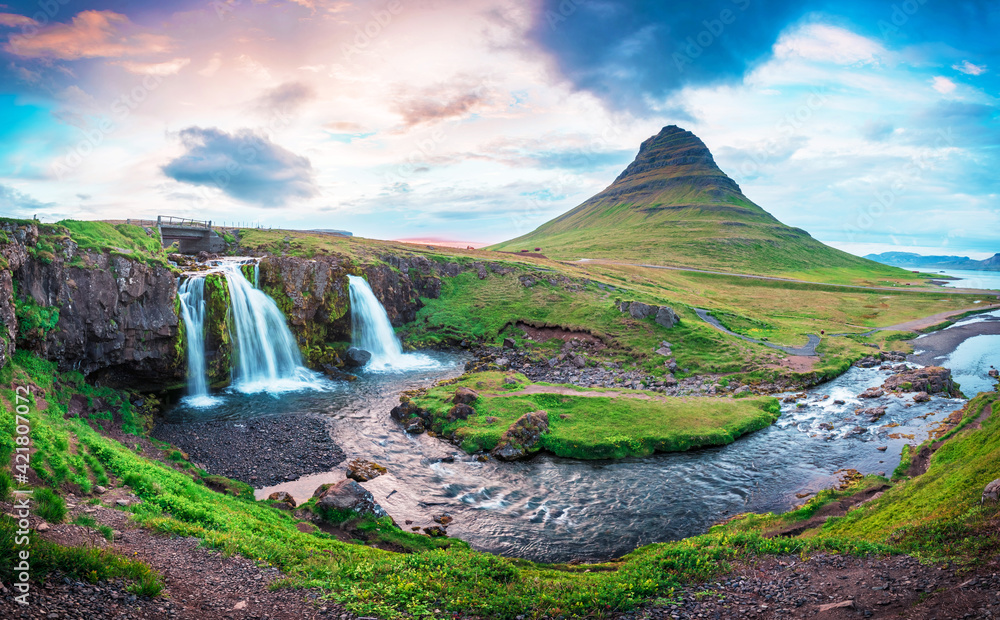 Beautiful natural magical scenery with a waterfall Kirkjufell near the volcano at dawn in Iceland. Exotic countries. Amazing places. Popular tourist atraction. (Meditation, antistress - concept).