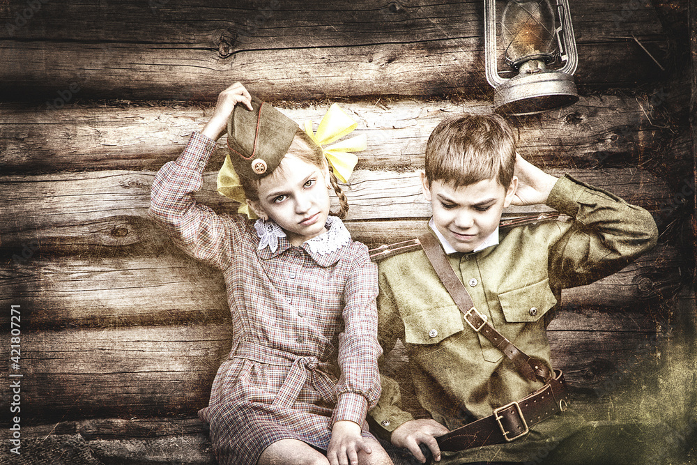 Postcard, stylized as vintage for the Victory Day. A boy in a military uniform and a girl in an old dress. The theme of May 9, Victory Day in Russia. Soft selective focus, added noise.