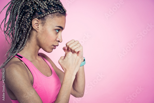 Beautiful girl doing exercises and sport. Posing on a pink colored background