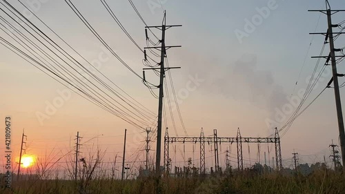 Electricity substation with green grass field in the morning light, Transmission line of electricity to rural field