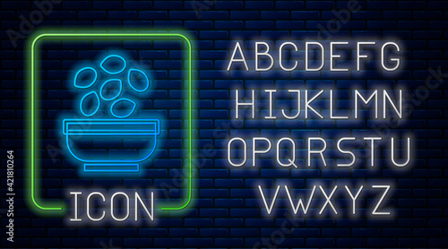 Glowing neon Seeds in bowl icon isolated on brick wall background. Neon light alphabet. Vector