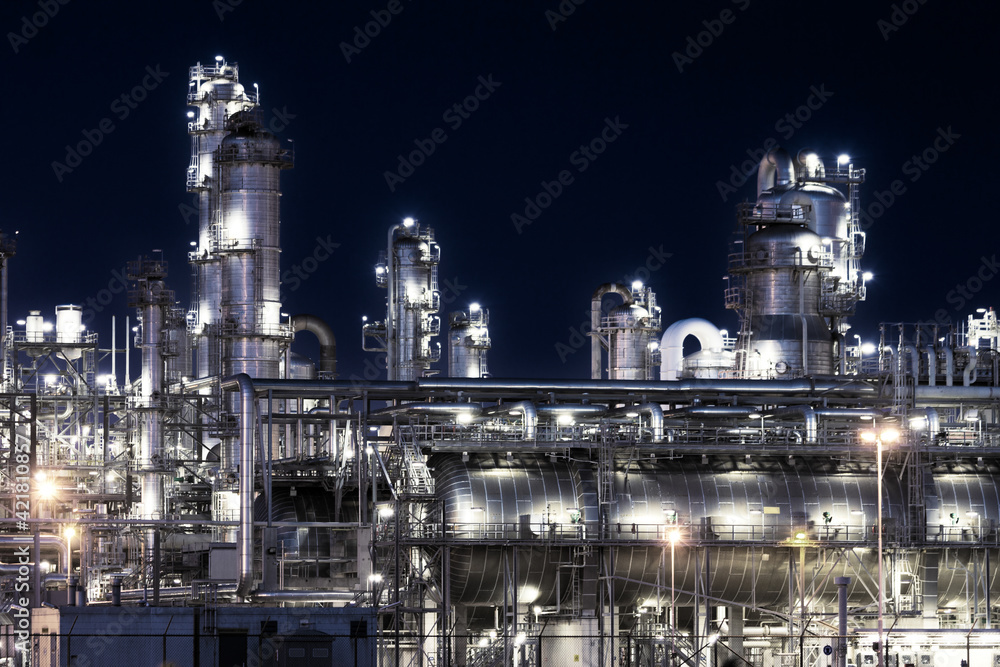 Industrial pipelines of an oil refinery power station at night