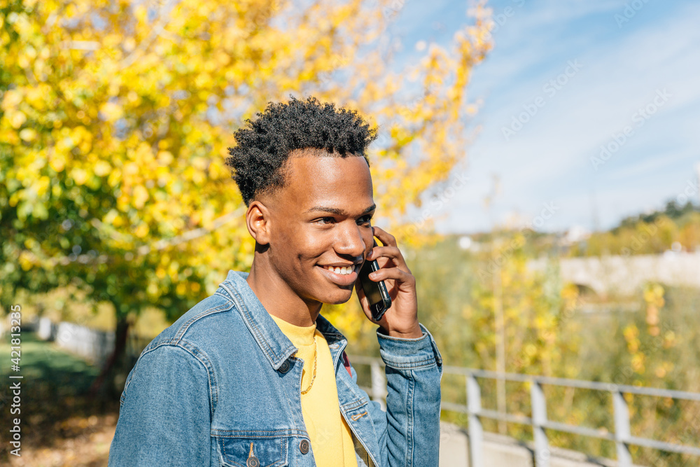 Portrait of a smiling afro style guy talking on his mobile phone Portrait of a smiling afro style guy talking on his mobile phone