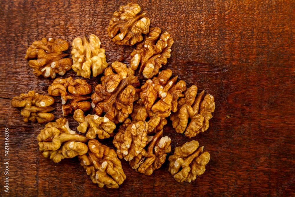 Walnuts sprinkled on a square board on a wooden table. Walnuts sprinkled on a square board on a wooden table.