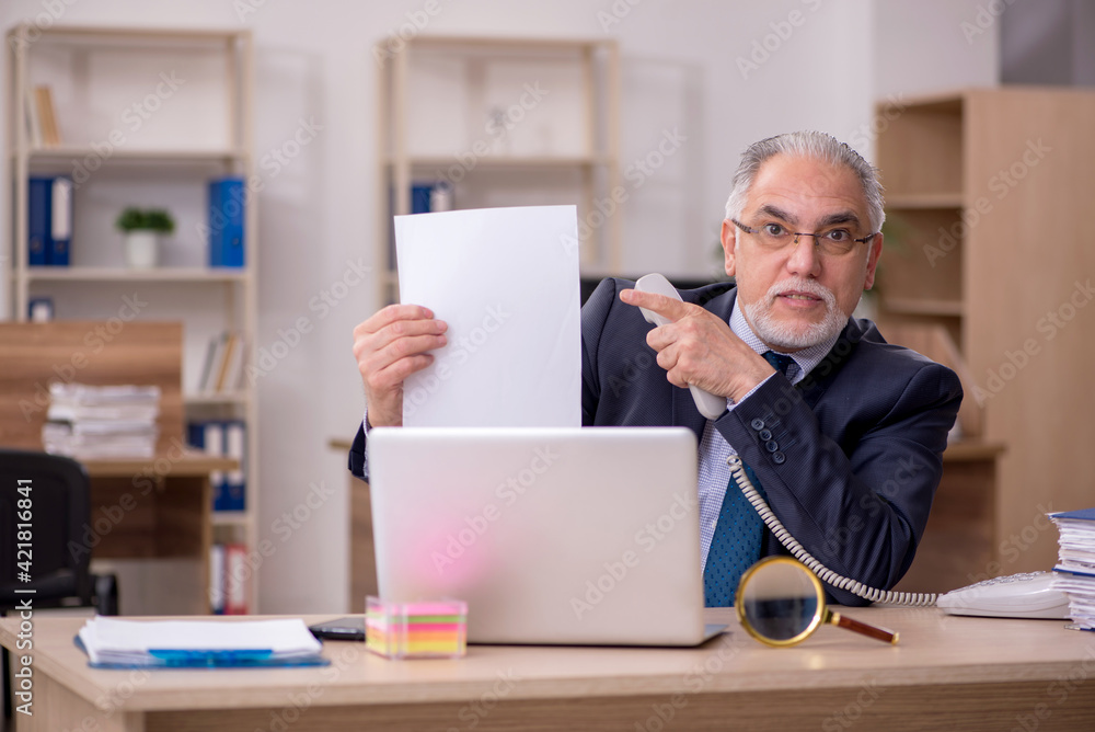 Old businessman employee sitting at workplace Old businessman employee sitting at workplace
