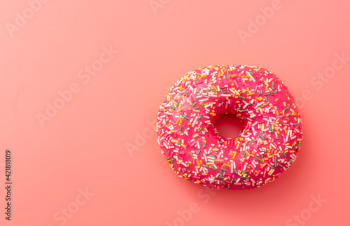 Red donut on a pink background.