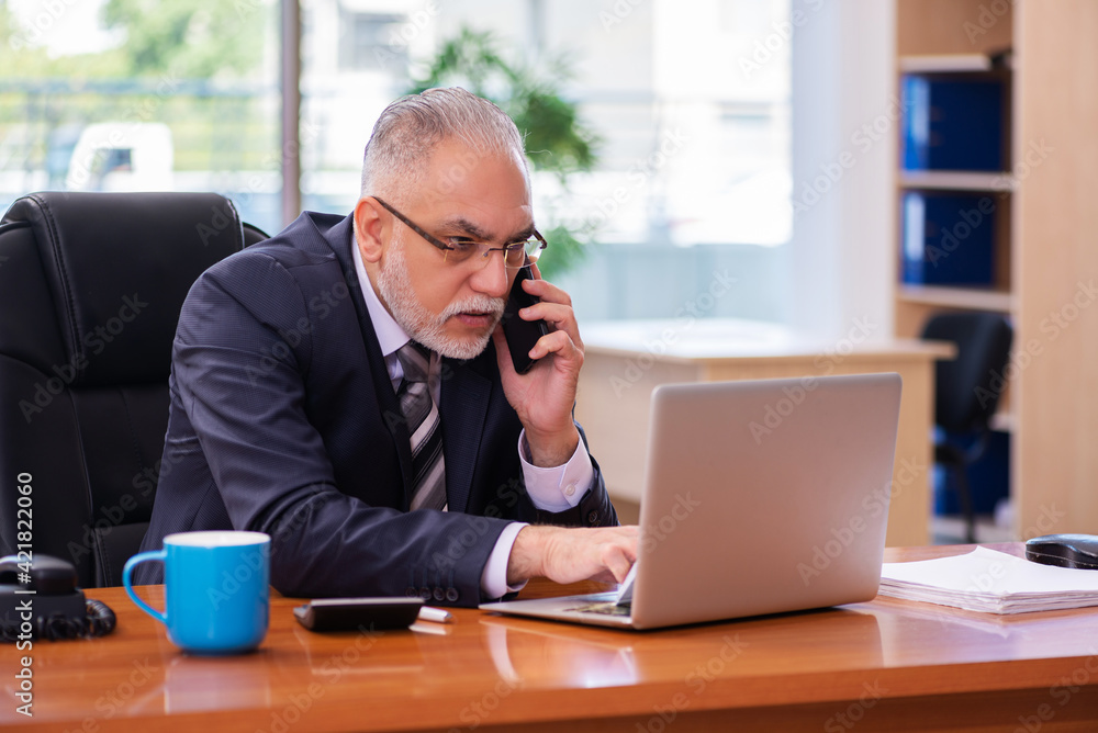 Old businessman employee working in the office Old businessman employee working in the office
