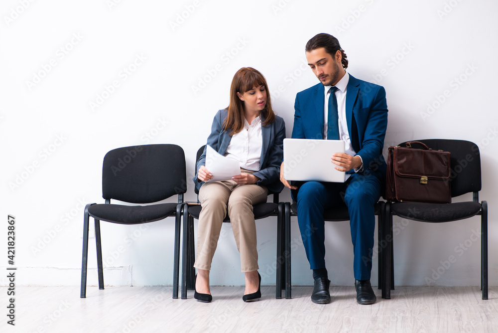 Young businessman and businesswoman waiting for an interview at Young businessman and businesswoman waiting for an interview at