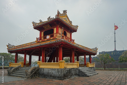 Colorful traditional pavilion with a flagpole in the background in Hue  Vietnam