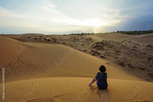 Girl watching the sunset in the desert in Mui Ne, Vietnam
