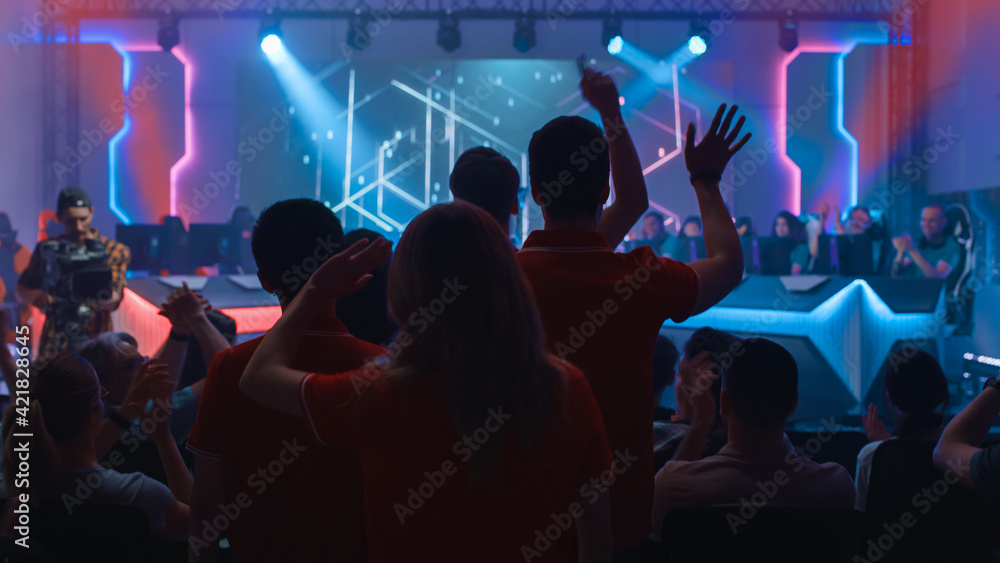 Esport Team of Professional Gamers Enter Video Game Championship Arena. Cyber Games Tournament Event with Crowd of Fans Cheering for Favourite Players. Online Streaming Entertainment. Esport Team of Professional Gamers Enter Video Game Championship Arena. Cyber Games Tournament Event with Crowd of Fans Cheering for Favourite Players. Online Streaming Entertainment.