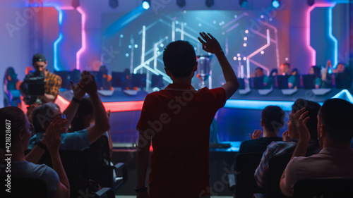 Esport Professional Gamer Enters Video Game Championship Arena. Cyber Games Tournament Event with Crowd of Fans and Spectators Cheering for Favourite Players. Online Streaming Entertainment © Gorodenkoff