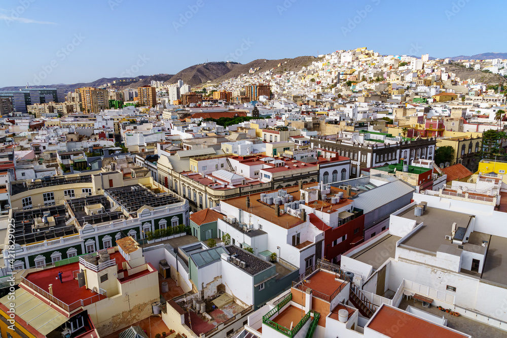 Aerial view of the city of Las Palmas, small white and brightly colored houses by the sea with blue sky and sunny day. Gran Canaria.