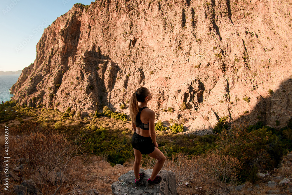high angle view of woman standing on stone and enjoying on view of mountain landscape. high angle view of woman standing on stone and enjoying on view of mountain landscape.
