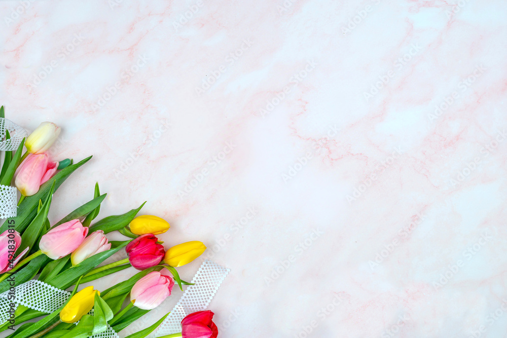 Tulips on a marble surface. Floral background with copy space for placing text for the design of greeting posts, advertising campaigns, florist business cards, souvenirs, printing on fabric, cover