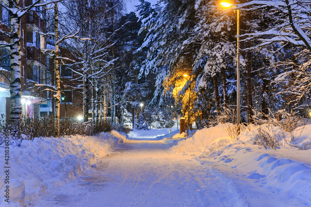 Snow-covered pedestrian street in the residential district after a snow-storm in the morning or evening in Finland.