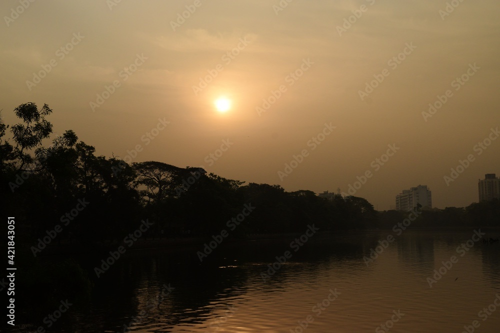hazy sunrise in the morning at rabindra sarobar lake, kolkata, west bengal, india