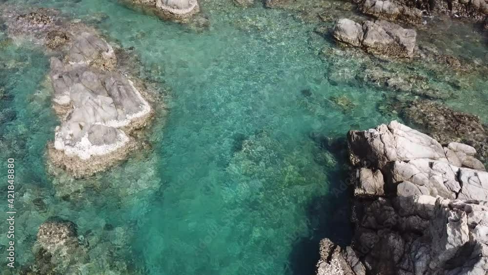 Breathtaking top aerial view of azure ocean and rocky sea cliffs. Drone flies over the turquoise ocean against the backdrop of rocks. Breathtaking top aerial view of azure ocean and rocky sea cliffs. Drone flies over the turquoise ocean against the backdrop of rocks.