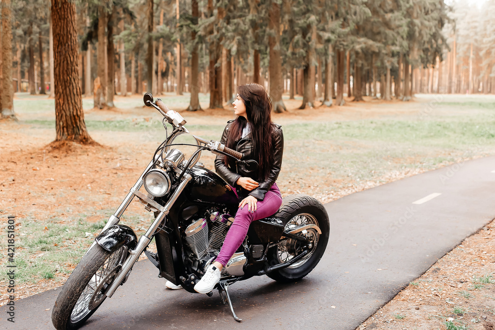 beautiful brunette riding a motorcycle in the park beautiful brunette riding a motorcycle in the park