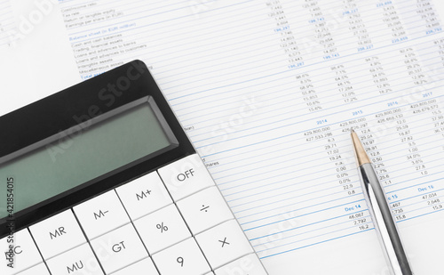 Financial charts and a calculator on the accountant's desk. Calculating profits, taxes, and paying employees salaries.