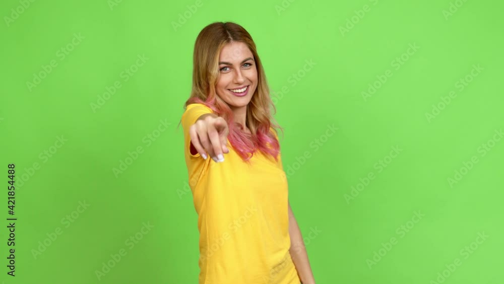 Young blonde woman showing and lifting a finger in sign of the best over isolated background on green screen chroma key Young blonde woman showing and lifting a finger in sign of the best over isolated background on green screen chroma key