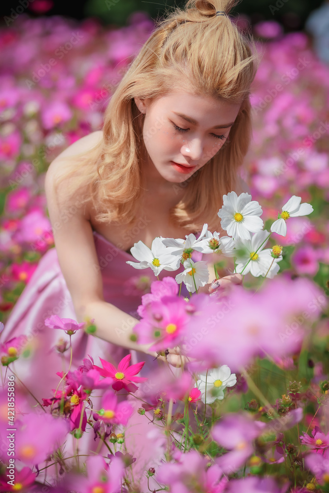Beautiful girl in a field of cosmos flowers on a sunny day Beautiful girl in a field of cosmos flowers on a sunny day