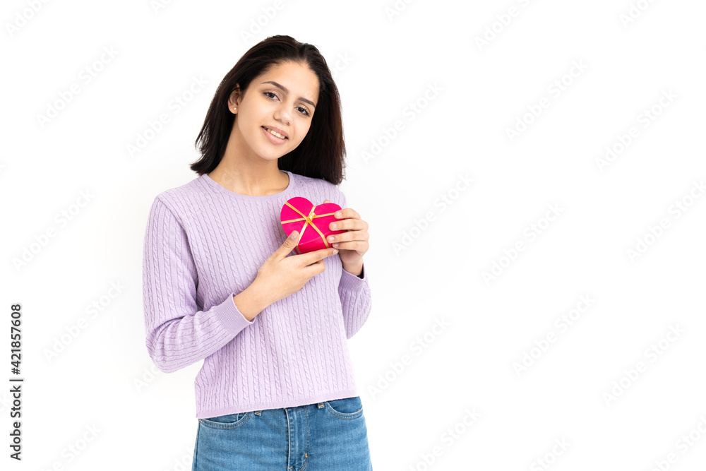 Latin woman with heart shaped gift box in hands on white background Latin woman with heart shaped gift box in hands on white background