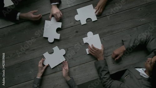 Business teamwork with white puzzle of four pieces cooperation unity concept