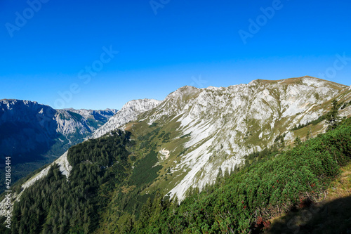 The view on the Alpine valley from the way to Hohe Weichsel in Austria. There is a dense forest on the steep slopes. View on Hochschwab. Clear and bright day. Calmness and peace.