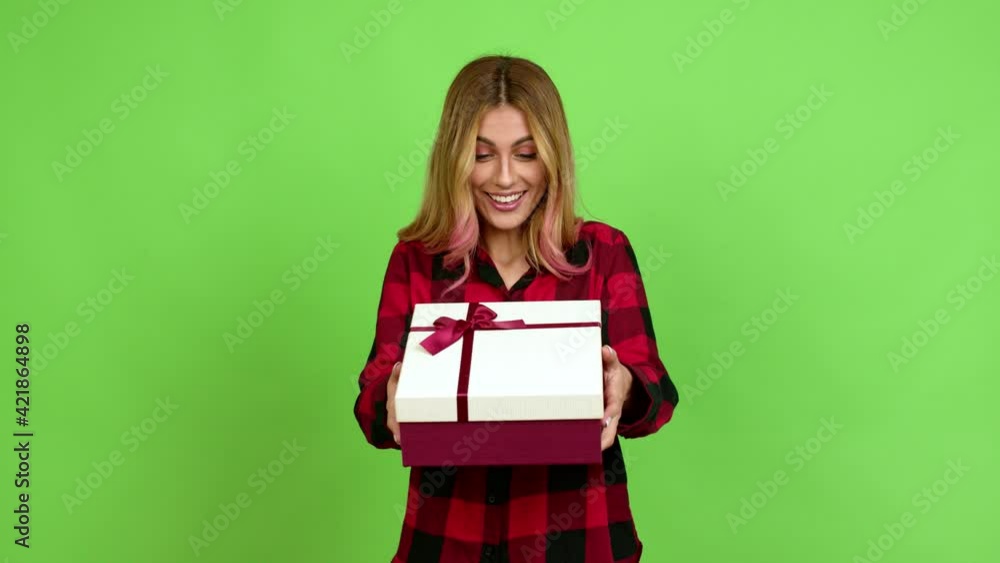 Young blonde woman happy and holding a gift over isolated background on green screen chroma key Young blonde woman happy and holding a gift over isolated background on green screen chroma key