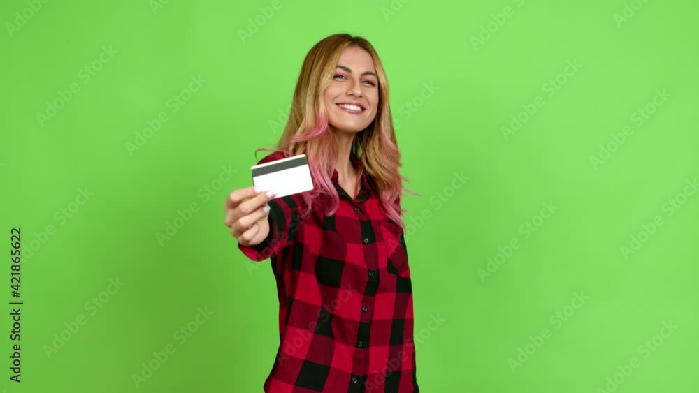 Young blonde woman happy and holding a credit card over isolated background on green screen chroma key Young blonde woman happy and holding a credit card over isolated background on green screen chroma key