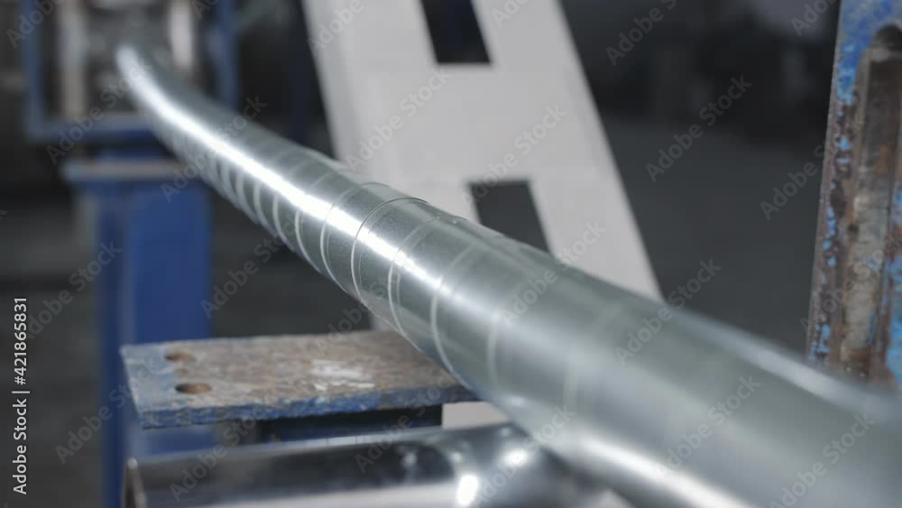 A thick armored power cable moves along the rails on the production line in the factory. A thick armored power cable moves along the rails on the production line in the factory.