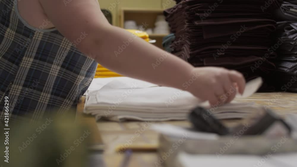 An employee of a garment factory lays out manufactured products, working day at the clothing factory, fabric production An employee of a garment factory lays out manufactured products, working day at the clothing factory, fabric production