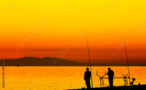 Fishermen beside the Marmara Sea and the boat maintenance pier at sunset