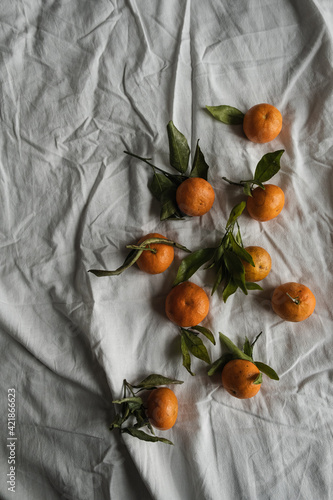 Wallpaper Mural Raw oranges, mandarins fruits with green leaves on grey crumpled linen cloth. Healthy food concept. Flat lay, top view. Torontodigital.ca