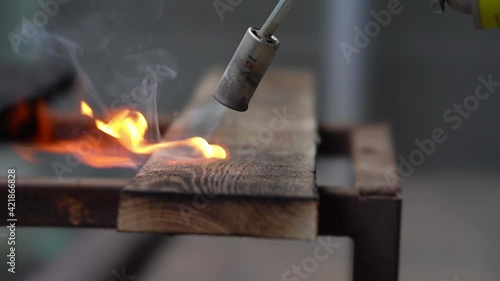 brushing wood with fire, burning wood with fire, burner