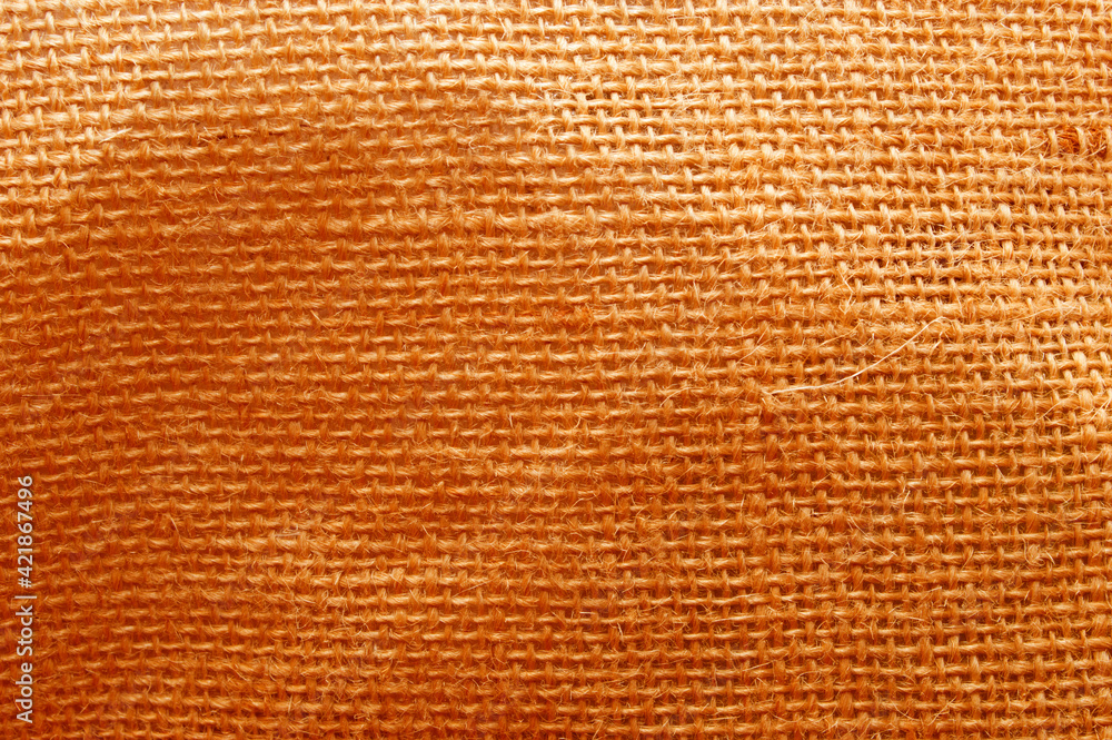 Fototapeta premium The texture is orange-colored burlap. Coarse fabric.