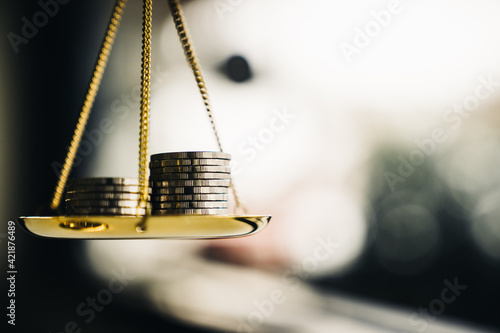 Coins stack with balance scale. Money management, financial plan, time value of money, business idea and Creative ideas for saving money concept.  photo