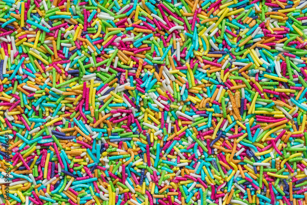 Tiny rod-shaped bits of candy used in the bakery as cakes topping. Rainbow sprinkles top view Tiny rod-shaped bits of candy used in the bakery as cakes topping. Rainbow sprinkles top view