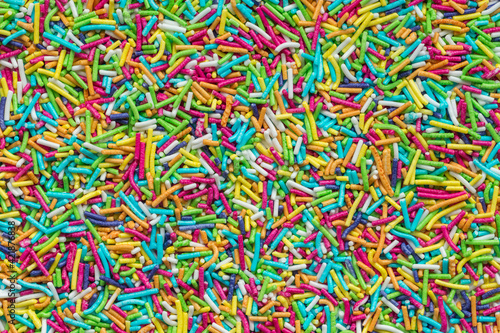 Tiny rod-shaped bits of candy used in the bakery as cakes topping. Rainbow sprinkles top view