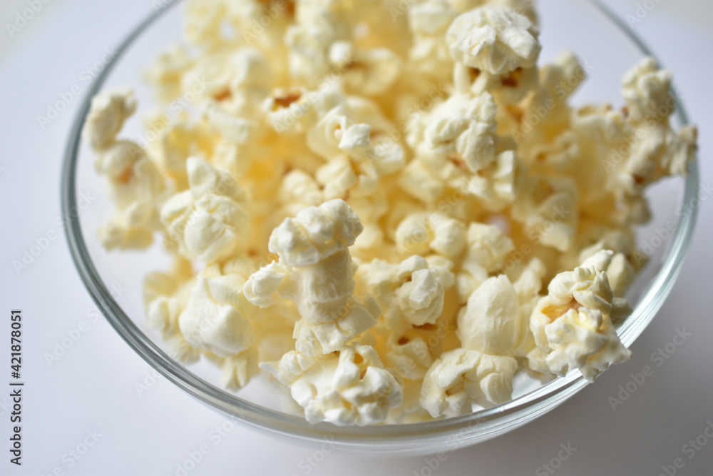 Glass saucer with popcorn on a white background Glass saucer with popcorn on a white background